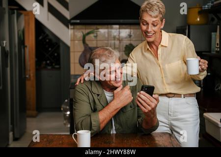 Kaukasisches älteres Paar, das Kaffee in der Küche genießt Stockfoto