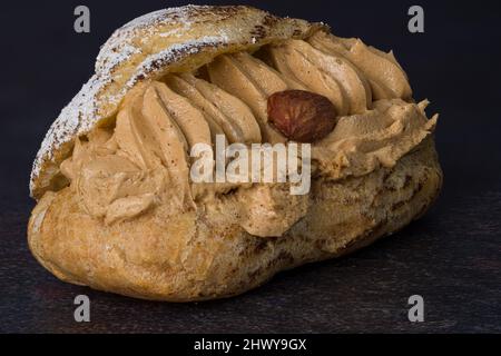 Fotografieren Sie auf einem schwarzen Hintergrund eines köstlichen Paris-Brest Stockfoto