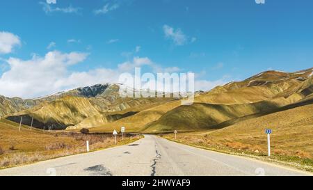 Kurvenreiche Asphaltstraße in einer bergigen Gegend Stockfoto