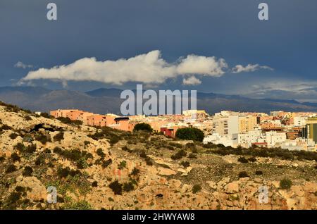 Dunkle Regenwolken über der darden Landschaft und der Stadt Almeria in Andalusien im Süden Spaniens. Stockfoto