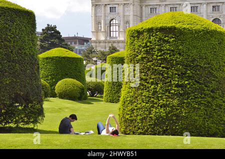 Menschen entspannen im Garten vor dem Naturhistorischen Museum im Frühjahr, Maria Theresien Platz in Wien Österreich. Stockfoto