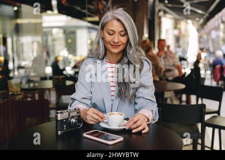 Asiatische Frau mit einer Tasse Kaffee im Café Stockfoto