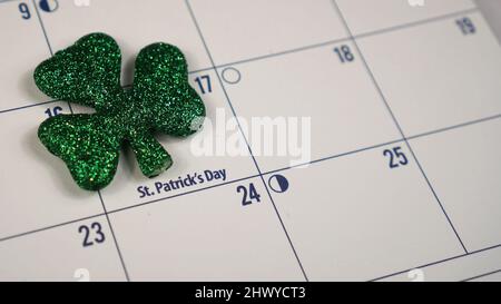 Der glitzernde Kleeblatt auf einem Kalender markiert den St. Patrick’s Day am 17. März. Stockfoto