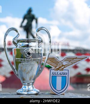 14. Juni 2021, Rom, Italien. Das Logo des S.S. Football Club Lazio und der UEFA Champions League Cup vor dem Hintergrund eines modernen Stadions. Stockfoto