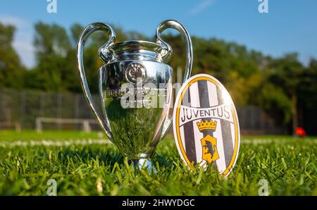 30. August 2021, Turin, Italien. Das Juventus Fußballverein-Emblem und der UEFA Champions League Cup auf dem grünen Rasen des Stadions. Stockfoto