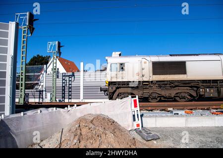 Oldenburg, Deutschland. 08. März 2022. Ein Zug fährt an der Baustelle der Strecke Oldenburg-Wilhelmshaven vorbei. Kritiker einer Güterzugstrecke durch Oldenburg sind mit einer Verfassungsbeschwerde in Karlsruhe gescheitert. Die Strecke zwischen Oldenburg und Wilhelmshaven wird ausgebaut, um die Verbindungen zum JadeWeserPort-Hafen zu verbessern. Die Stadt Oldenburg hätte eine Umgehungsstraße bevorzugt, um kilometerlange Lärmschutzwände zu vermeiden. Quelle: Sina Schuldt/dpa/Alamy Live News Stockfoto