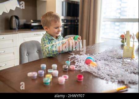 Das Kind war damit beschäftigt, Eier zu Ostern zu dekorieren Stockfoto