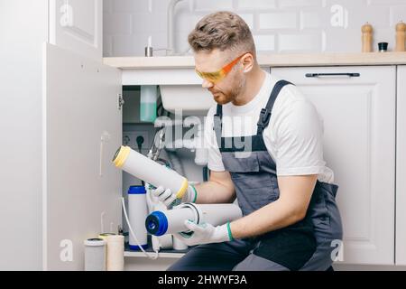 Klempner arbeiten austauschbar verschmutzt verwendet Aqua-Filter für die Filtration von Umkehrosmose-Wasser. Stockfoto