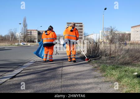 Magdeburg, Deutschland. 08. März 2022. Mitarbeiter der Abfallwirtschaft gehen mit Mülltüten auf einem Grundstück entlang. Nach einer pandemischen Pause rufen die Landeshauptstadt Magdeburg sowie Verbände und Initiativen erneut alle Magdeburger Einwohner auf, sich unter dem Motto „Magdeburg putzt sich!“ an der Frühjahrsputz zu beteiligen. ('Magdeburg räumt auf!'). Der offizielle Kampagnenzeitraum beginnt am 11. März und endet am 30. April. Quelle: Peter Gercke/dpa-Zentralbild/ZB/dpa/Alamy Live News Stockfoto