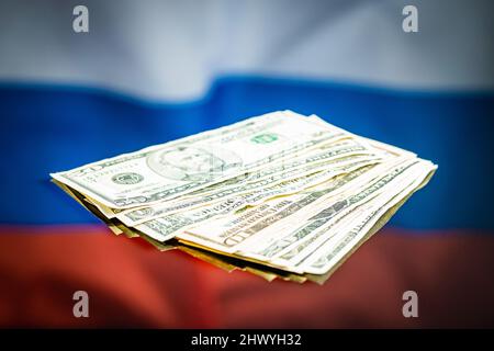 Dollar-Banknoten vor der russischen Flagge. Die US-Währung in Papierform. Stockfoto