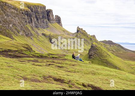 Ein Paar mittleren Alters genießt die Aussicht auf dem Quiraing Walk im Norden der Isle of Skye, Highland, Schottland, Großbritannien. Stockfoto