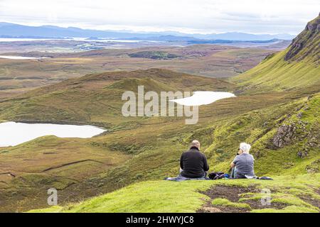 Ein Paar mittleren Alters genießt die Aussicht auf dem Quiraing Walk im Norden der Isle of Skye, Highland, Schottland, Großbritannien. Stockfoto