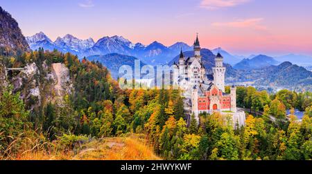 Schloss Neuschwanstein (Schloss Neuschwanstein) Bayern, Deutschland. Vorderansicht des Schlosses und der Queen Mary's Brücke bei Sonnenaufgang. Die bayerischen Alpen im Stockfoto