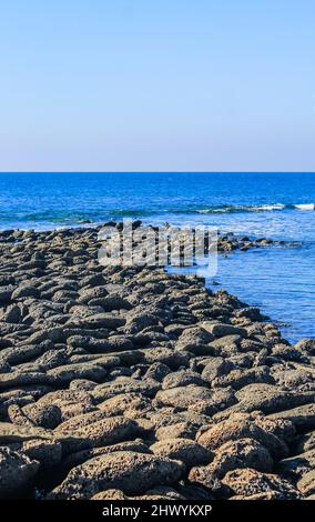 Giant's Causeway in St. Martin's Island, Bangladesch. Magischer Sonnenaufgang, Wolken und Wellen treffen auf die Küste. Giant's Causeway sieht aus wie ein Steg. Stockfoto