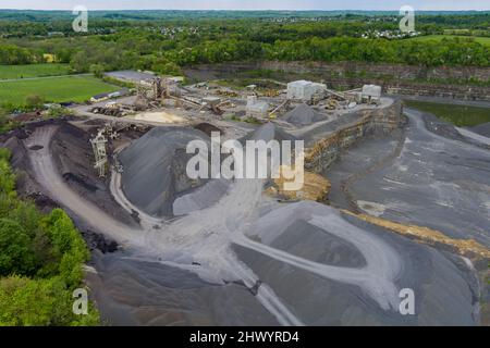 Mobile Brecher machen aus dem Tagebau Sand in mobile Backenbrecher schwere Maschinen im Bergbaubruch, Bagger und Muldenkipper Stockfoto