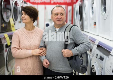 Europäische Ehegatten im reifen Alter entscheiden sich für eine Waschmaschine Stockfoto