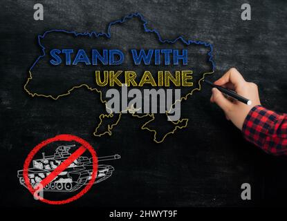 Mädchen zeichnet eine Karte der Ukraine mit dem Text stand mit der Ukraine auf der Tafel Stockfoto