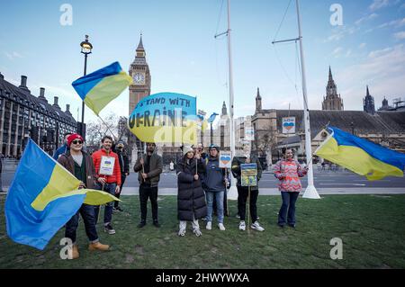 London, Großbritannien. 8.. März 2022. Ukrainische Unterstützer versammeln sich in der Nähe des Parlaments, während der Präsident der Ukraine, Wolodymyr Zelenskyy, sich darauf vorbereitet, britische Parlamentsabgeordnete per Videolink anzusprechen, um eine Erklärung vor dem Unterhaus zu lesen. Kredit: Guy Corbishley/Alamy Live Nachrichten Stockfoto