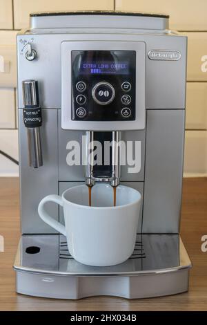 Delonghi Bean to Cup Kaffeemaschine, die frischen Kaffee in eine weiße Tasse ausgibt Stockfoto