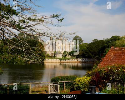 Palace House, Beaulieu, von der anderen Seite des Beaulieu River und Mill Dam, New Forest, Hampshire. Stockfoto