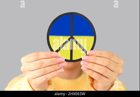 Frau, die das Symbol des Friedens in der Ukraine in blauen und gelben Farben gehalten hat. Stop war Concept Stockfoto