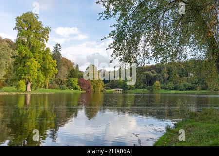 Blick auf die Herbstfarben rund um den See in den Stourhead Gardens in Wiltshire Stockfoto