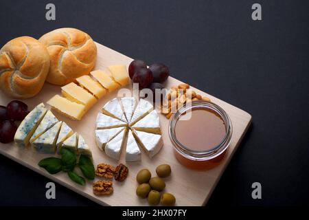 Verschiedene geschnittene ​​cheeses - Camembert Brie, Camembert blau und Parmesan Käse auf einem Brett gestapelt Stockfoto