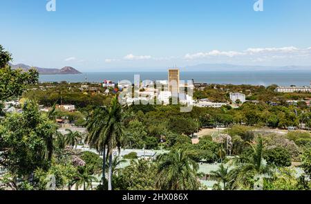 Die Skyline von Managua von der Tiscapa Lagune aus blickt auf den Xolotlan See im Hintergrund und Militärsportkurse im nahen Vordergrund. Stockfoto