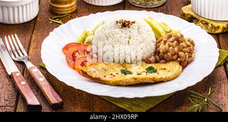 Reis und Bohnen serviert mit pommes Frites, gegrilltem Hähnchenfilet und Salat, typisch brasilianisches Essen Stockfoto