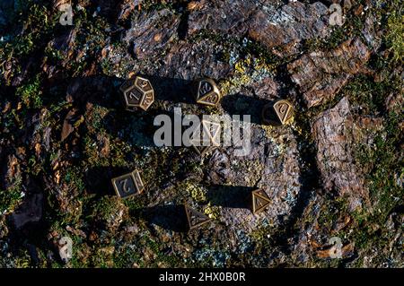 Overhead-Bild eines Sets von metallischen Würfeln auf einer hölzernen Oberfläche in der Sonne Stockfoto