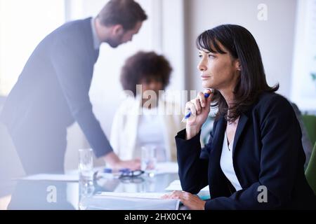 Die Arbeit mit Teamarbeit erledigen. Eine Aufnahme einer Gruppe von Geschäftskollegen, die sich im Sitzungssaal treffen. Stockfoto