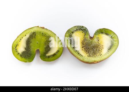 Flaches Lay-Bild von zwei Hälften einer Kiwi mit Herzform auf weißem Bakkgrund horizontal gegenüberliegende Position Stockfoto