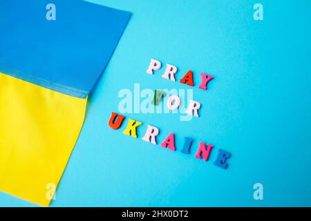Betet für die Ukraine. Nahaufnahme der blauen und gelben ukrainischen Flagge während des Krieges. Invasion in der Ukraine. Eskalation der russischen Besatzung Stockfoto