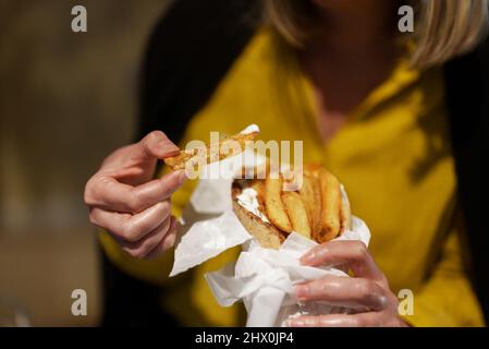 Frau isst Pita mit pommes frites. Stockfoto