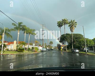 Blick durch die Windschutzscheibe von Autofahrten an regnerischen Tagen mit einem Regenbogen in Los Angeles, CA Stockfoto