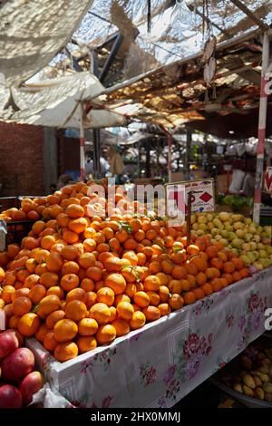 HURGHADA, ÄGYPTEN - 20. FEBRUAR 2022: Orangen auf der Theke des authentischen ägyptischen Marktes. Frisches Obst auf dem Straßenbasar Stockfoto