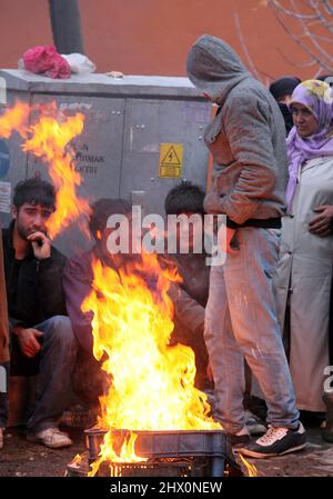 VAN, TÜRKEI - 25. OKTOBER: Erdbebenopfer sitzen am 25. Oktober 2011 in Van, Türkei, um ein Lagerfeuer herum. Beim Erdbeben in Van-Ercis wurden 604 Menschen getötet und 4152 verletzt. Stockfoto