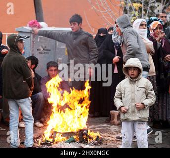 VAN, TÜRKEI - 25. OKTOBER: Erdbebenopfer sitzen am 25. Oktober 2011 in Van, Türkei, um ein Lagerfeuer herum. Beim Erdbeben in Van-Ercis wurden 604 Menschen getötet und 4152 verletzt. Stockfoto