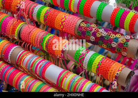 Bild eines Stapels von Lederarmbändern mit verschiedenen Formen und Farben in einem Stand zum Verkauf auf einer Straßenmesse ausgesetzt Stockfoto