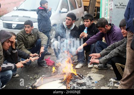 VAN, TÜRKEI - 25. OKTOBER: Erdbebenopfer sitzen am 25. Oktober 2011 in Van, Türkei, um ein Lagerfeuer herum. Beim Erdbeben in Van-Ercis wurden 604 Menschen getötet und 4152 verletzt. Stockfoto