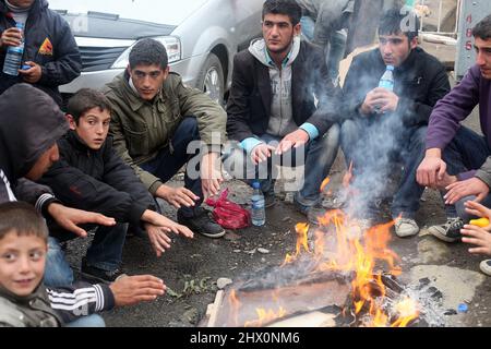 VAN, TÜRKEI - 25. OKTOBER: Erdbebenopfer sitzen am 25. Oktober 2011 in Van, Türkei, um ein Lagerfeuer herum. Beim Erdbeben in Van-Ercis wurden 604 Menschen getötet und 4152 verletzt. Stockfoto