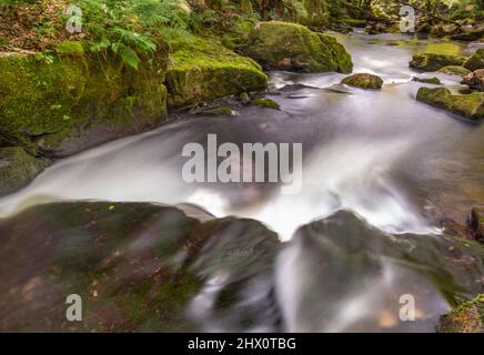 Abstrakter Blick auf Wasserkaskaden mit Bewegungsunschärfen bei einer Reihe spektakulärer Kaskaden und Wasserfälle entlang eines Abschnitts des Flusses Fowey, einer beliebten Tour Stockfoto