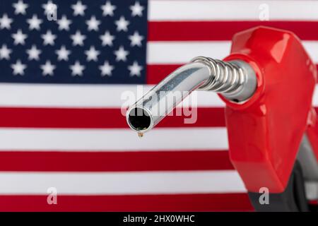 Gas tropft von der Kraftstoffdüse mit amerikanischer Flagge. Benzinknappheit, Preis und Ethanolkonzept. Stockfoto