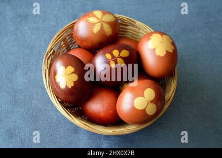 Draufsicht auf den Osterkorb. Natürlich gefärbte Eier mit Zwiebelschalen im Korb Stockfoto