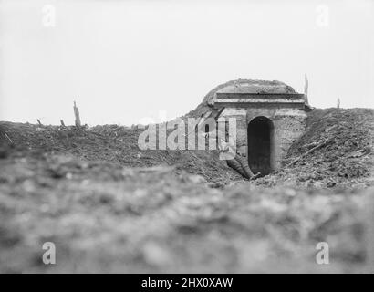 Ein britischer Soldat sitzt in zerstörten Verteidigungsarbeiten am Eingang eines Betonsäulenkastens, der im Winter 1917, kurz vor dem deutschen Rückzug auf die Hindenburg-Linie vom 1917. März, bei Operationen auf der Ancre zerstört wurde. Stockfoto