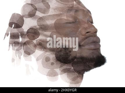 Ein Porträt eines afroamerikanischen Mannes kombiniert mit Aquarellflecken. Stockfoto