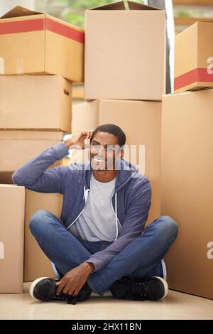 HES Umzug. Ein hübscher junger Mann, der Kisten verpackt. Stockfoto