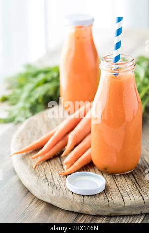 Nahaufnahme von zwei Flaschen frisch zubereitetem Karottensaft zum Trinken. Stockfoto