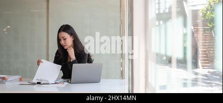 Ernteaufnahme der Firma Asian Frau Investment Consultant Analyse des Unternehmens jährlichen Finanzbericht Bilanz der Arbeit mit Dokumenten Stockfoto