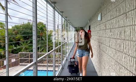 Junge Frau checkt in einem Motel ein Stockfoto